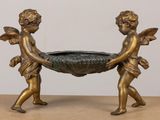 une statue en bronze représentant deux chérubins tenant un bol