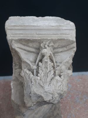 a stone sculpture of a woman and a bird on top of a pillar