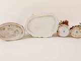 three porcelain figurines of different shapes and sizes on a white surface