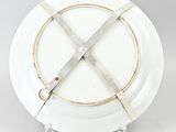 an image of a white plate with a metal cross on it