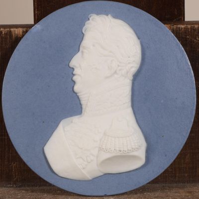 un gros plan d'une assiette bleue et blanche représentant le buste d'un homme