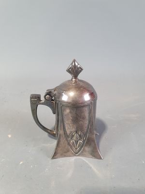une théière en argent avec une anse, posée sur une table