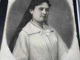 an old picture of a woman with long hair in a white dress