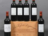 six bottles of red wine in a wooden crate on a table