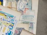 a pile of art on the floor next to a table