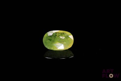 un gros plan d'une pierre précieuse verte et blanche sur une surface noire