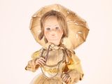 a doll that is wearing a yellow dress and a hat