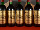 six bottles of wine are lined up on a table