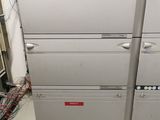 four refrigerators stacked on top of each other in a room