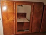 a wooden cabinet with a mirror on it in a room