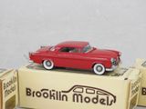 a red toy car sitting on top of a box
