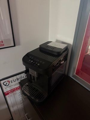 a coffee machine sitting on top of a table next to a poster