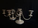 trois bougeoirs en argent sur fond noir