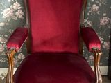une chaise rouge placée dans une pièce au papier peint à motifs floraux