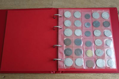 un classeur rouge contenant beaucoup de pièces de monnaie