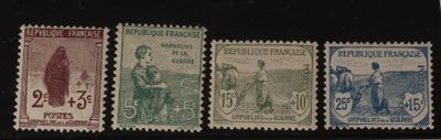 quatre timbres de couleurs différentes sur une surface noire avec un fond noir
