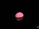 an image of a pink stone in the dark