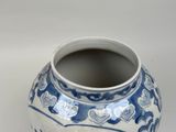 a blue and white vase sitting on a white surface