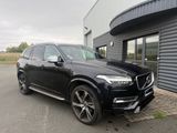 a black volvo suv parked in front of a building