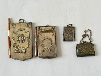 several antique silver metal items including a book, a purse, and a pen