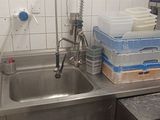 un évier en inox dans une cuisine où il y a beaucoup de vaisselle