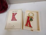 a keychain in a box with a letter k on it