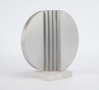 une image représentant une sculpture argentée posée sur une surface blanche