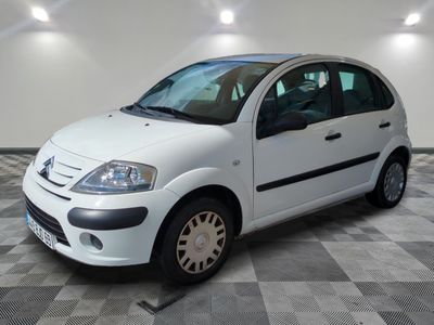 a picture of a small white car parked on a checkered floor