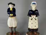 pair of ceramic figurines of a man and a woman in traditional clothing
