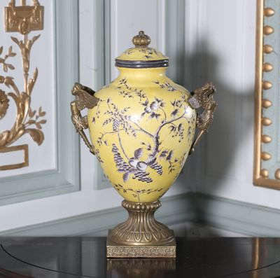 un vase jaune posé sur une table dans une pièce