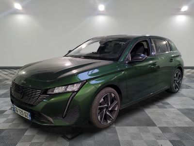 La voiture verte est garée sur un sol à damier, dans une pièce.