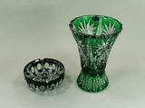 un vase en verre vert à côté d'un cendrier en verre noir