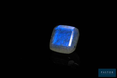 a close up of a glowing blue stone on a black surface