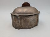 an old silver pot sitting on top of a white table
