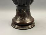 un vase noir orné d'un oiseau, posé sur une table