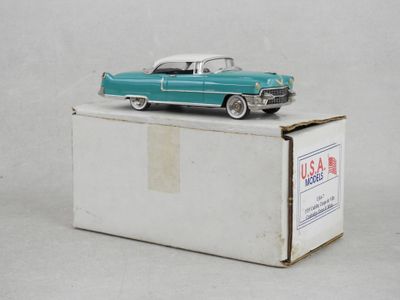 une petite voiture verte posée sur une boîte