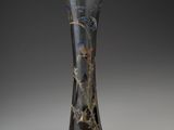 a glass vase with a design on it on a gray background
