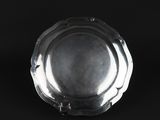 a close up of a silver plate on a black background
