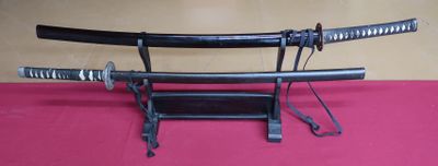 two samurai swords on a stand on a table