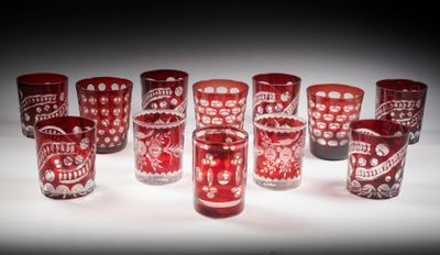 Plusieurs verres rouges sont alignés sur une surface blanche