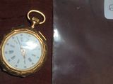 une montre de poche en or avec des chiffres romains