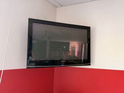 une télévision à écran plat fixée au mur au-dessus d'un lit