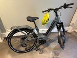 un vélo garé dans une pièce, avec un sac à l'arrière