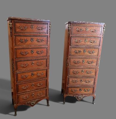 paire de commodes anciennes ornées de sculptures élaborées sur les côtés