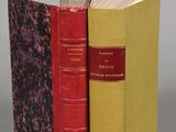 two red and yellow books sitting next to each other on a gray surface