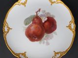 a plate with two apples on it on a black table