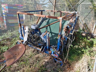 un tracteur qui est garé dans l'herbe près d'une clôture
