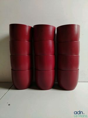 six gobelets rouges sont empilés les uns sur les autres sur une table