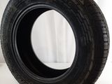 a close up of a tire on a white surface with a curtain in the background