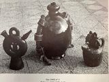 a black and white photo of a group of vases and figurines